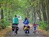 Eine Familie macht eine Fahrradtour und fährt dabei eine Allee entlang. Foto: Oliver König (LANUV)